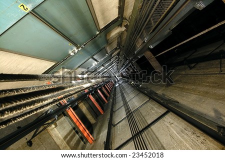 The view up inside a tall elevator shaft.