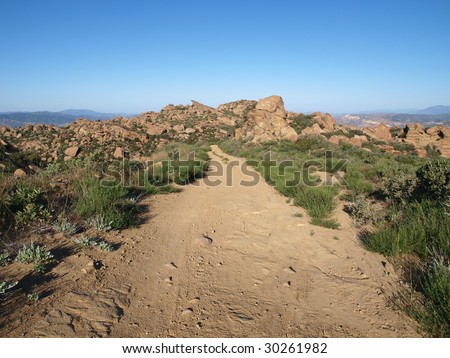 A simple dirt road on a rocky mountain ridge in Southern California.