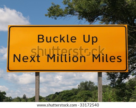 Buckle Up Next Million Miles highway sign.