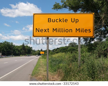 Buckle Up Next Million Miles highway sign.