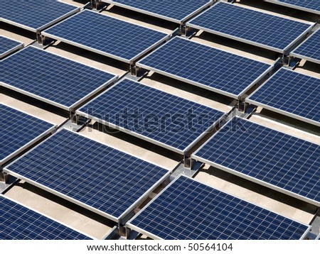 Photovoltaic solar panels on a concrete rooftop.