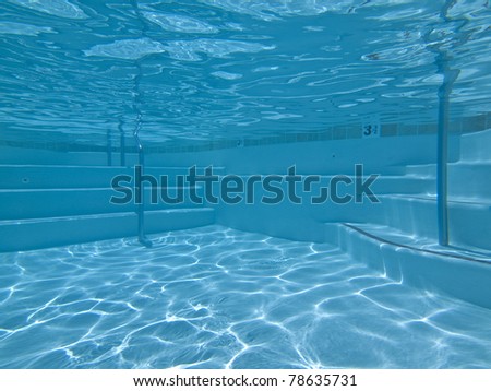 Underwater approach to stairs and seating in a clean suburban pool.