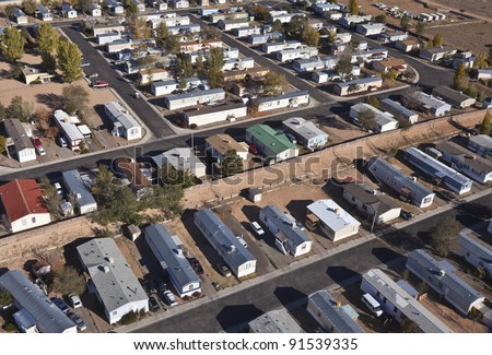 Aerial of aging mobile homes in bright desert sun.