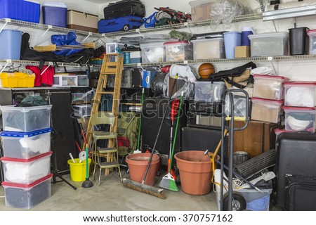 Residential garage full of junk and storage.