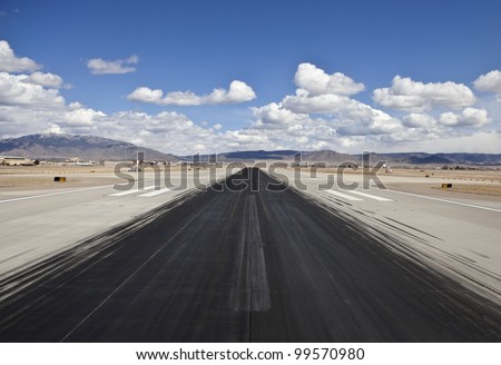 Heavy skid marks on a busy North American desert airport runway.