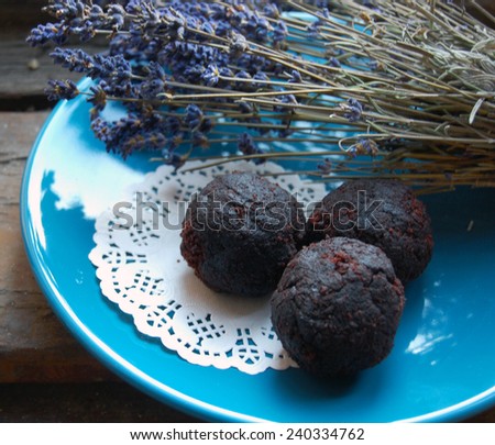 dark chocolate truffles with lavender on a dessert plate and wooden background