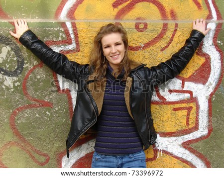 image with beautiful blond girl posing in front of graffiti wall