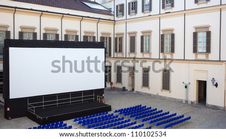 View of screen and Empty blue chairs for outdoor cinema