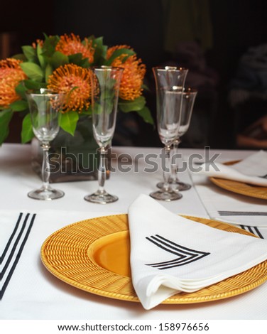 View of elegant table set with orange flowers