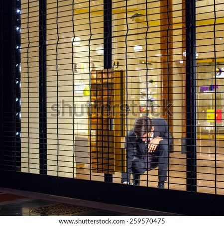 MILAN, ITALY - NOVEMBER, 24: Salesman close shop shutter on November 24, 2014