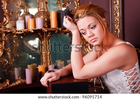 Sensual blonde girl in underwear next to a old mirror