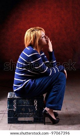 Girl sitting on the stool on red background