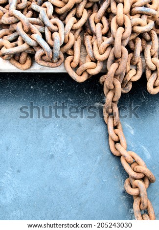 Detail from industrial rusty chains, isolated against a blue background