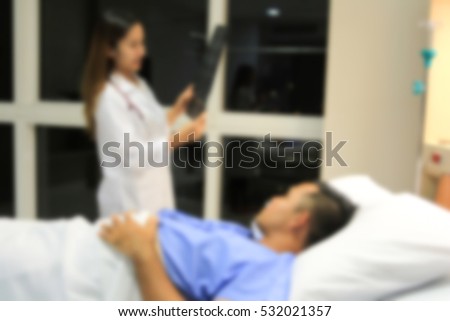 Blurred background Doctor holding drug bottle and prescribes medication to the patient in hospital room.