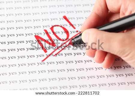 Woman's hand with red pen writing word 