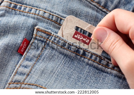 Tambov, Russian Federation- October 21, 2012: Woman\'s hand taking out label logo  from pocket of a pair Levi\'s Jeans. Studio shot. Levi Strauss &Co. is a American clothing company was founded in 1853.