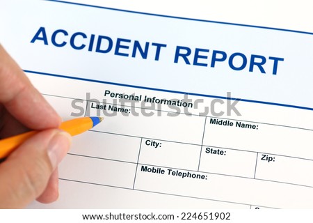 Accident report application form and human hand with ballpoint pen.