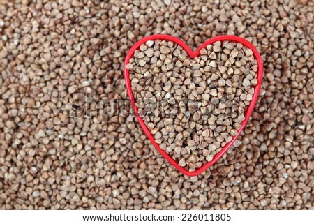 Buckwheat in a heart bowl. Close-up.