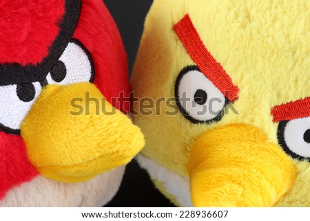 Tambov, Russian Federation - September 22, 2013: Red and Yellow Angry Birds soft toys on black background. Angry Birds is popular computer games, developed by Rovio Mobile.