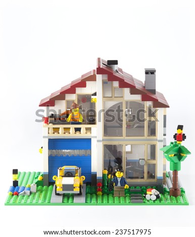 Tambov, Russian Federation - January 08, 2014 LEGO Family House with yellow car and couple minifigures on white background.  Lego manufactured by the Lego Group (Billund, Denmark).
