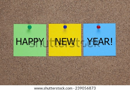 Three blanks post-it notes on cork board (bulletin board) with words Happy New Year!