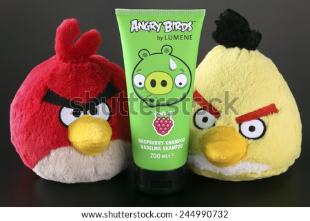 Tambov, Russian Federation - September 22, 2013 Red and Yellow Angry Birds soft toys and Angry Birds by LUMENE Raspberry Shampoo with Bad Piggies image on black background. Studio shot.