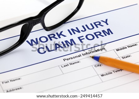 Work Injury claim form glasses and ballpoint pen