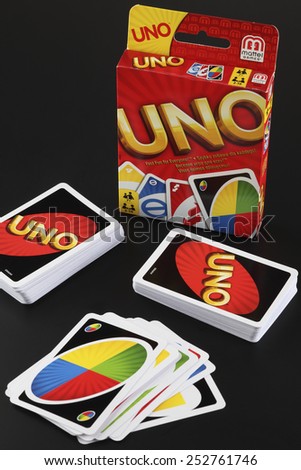 Tambov, Russian Federation - August 15, 2013 Decks of UNO game cards and UNO game box on black background.