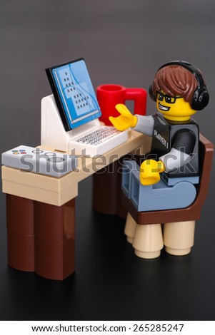 Tambov, Russian Federation - March 24, 2015 Lego Video Game Guy minifigure (player 1) at his  table with computer, gamepad and cup on black background. Studio shot.
