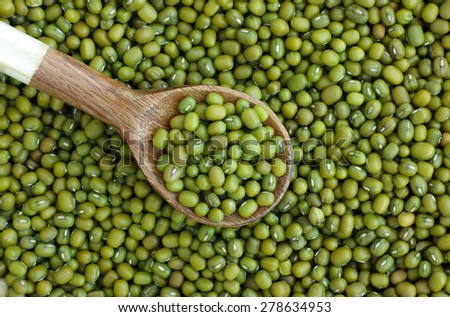 Mung beans (mash) in wooden spoon on mung beans background
