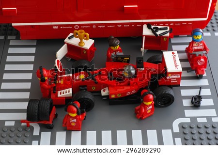 Tambov, Russian Federation - June 23, 2015 Lego team crew members are fixing wheel of Ferrari F14 T race car by LEGO Speed Champions. Studio shot.