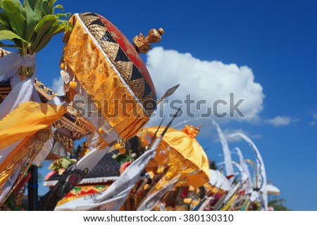Traditional ceremonial umbrellas and flags on beach at ceremony Melasti before Balinese New Year and silence day Nyepi. Holidays, festivals, rituals, art, culture of Indonesian people and Bali island.