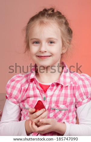 little cute girl smile and holding a strawberry