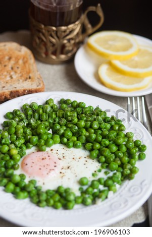 Breakfast: scrambled eggs with green peas, toast, tea, lemon