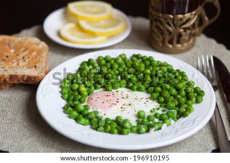 Breakfast: scrambled eggs with green peas, toast, tea, lemon