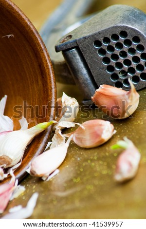 Stylish still life of garlic bulbs with crusher tool