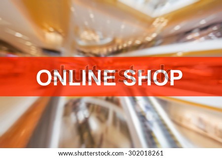 Online shop word with red line blurred interior of shopping mall with bokeh for banner business background