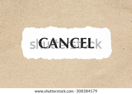 CANCEL word on white ripped paper on brown document texture