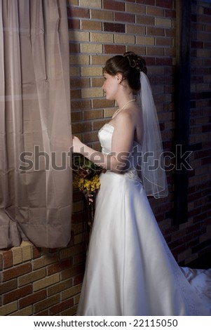 stock photo Young women looking out window in wedding dress