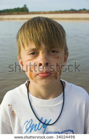 Boy with face painted at river