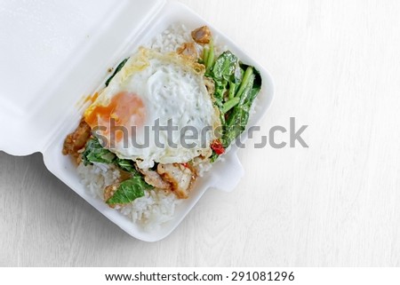 Basil fried rice with pork in white foam box