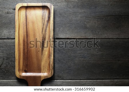 The brown wooden plate on a rustic table closeup. horizontal top view