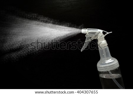 The mist spray bottle to spray water into the air, against a black background.