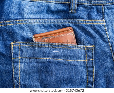 brown leather wallet in jeans back pocket blue