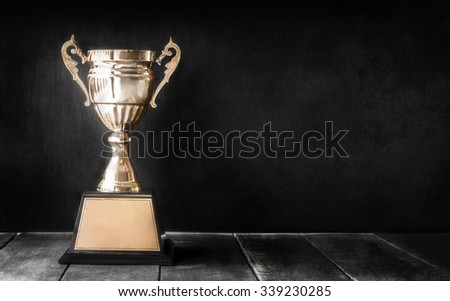 champion golden trophy on wood table with blackboard copy space