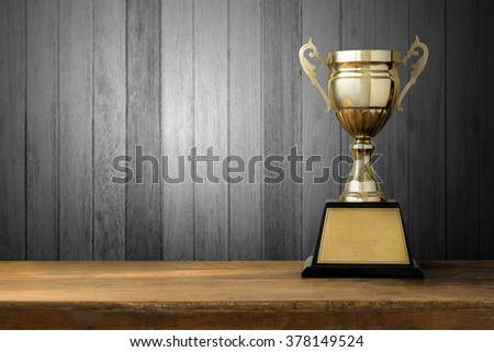 champion golden trophy on wood table with copy space