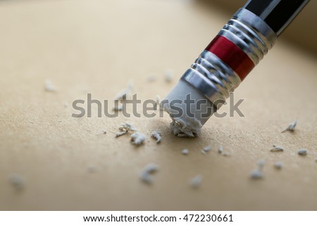 pencil eraser. pencil eraser removing a written mistake on a piece of paper.