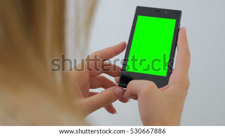 Woman using vertical smartphone with green screen. Close up shot of woman\'s hands with mobile Close up shot of woman\'s hands with mobile. White background