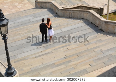 bridal couple standing on stairs to watch out