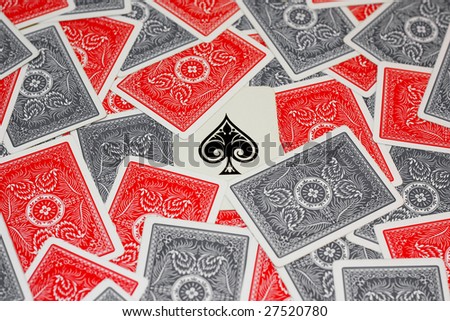 Ace of spade in the center surrounded by red and grey playing cards